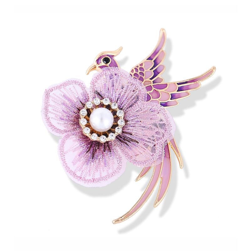 Close-up of embellished brooch with flowers and bird