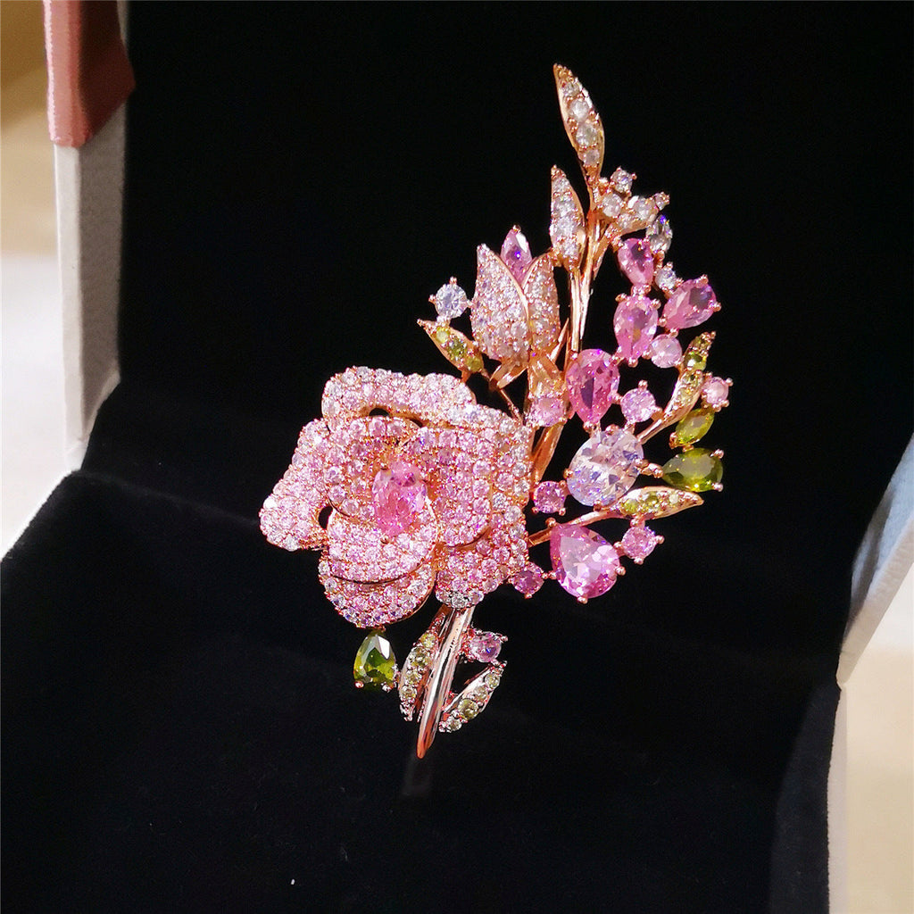 Pink rose bouquet brooch showcased on fabric