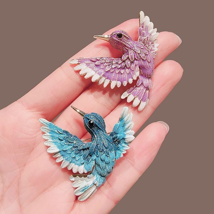 Retro blue wing bird brooch against a backdrop