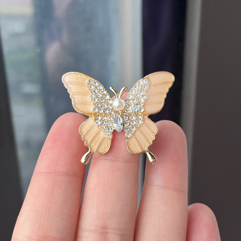 butterfly brooch styled on a dark blazer