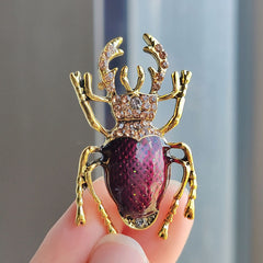 Purple Vintage Beetle Brooch on a black jacket