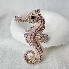 Elegant pink sea horse enamel pin displayed