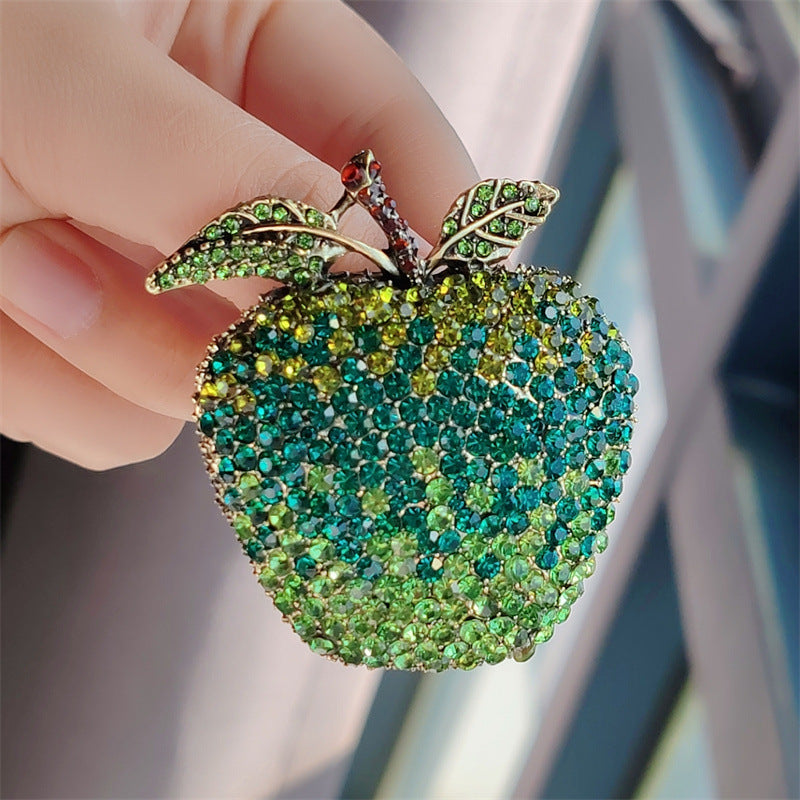 Playful fruit-themed brooch placed on a dark surface