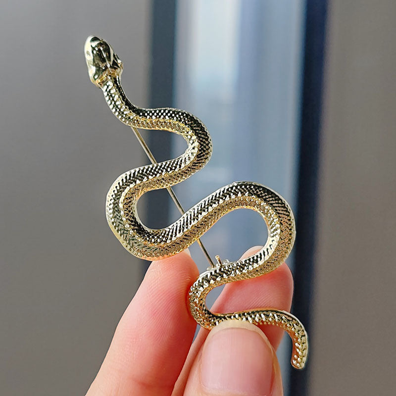 Gold python pin displayed on fabric