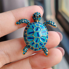 Stylish turtle brooch with rhinestones on display