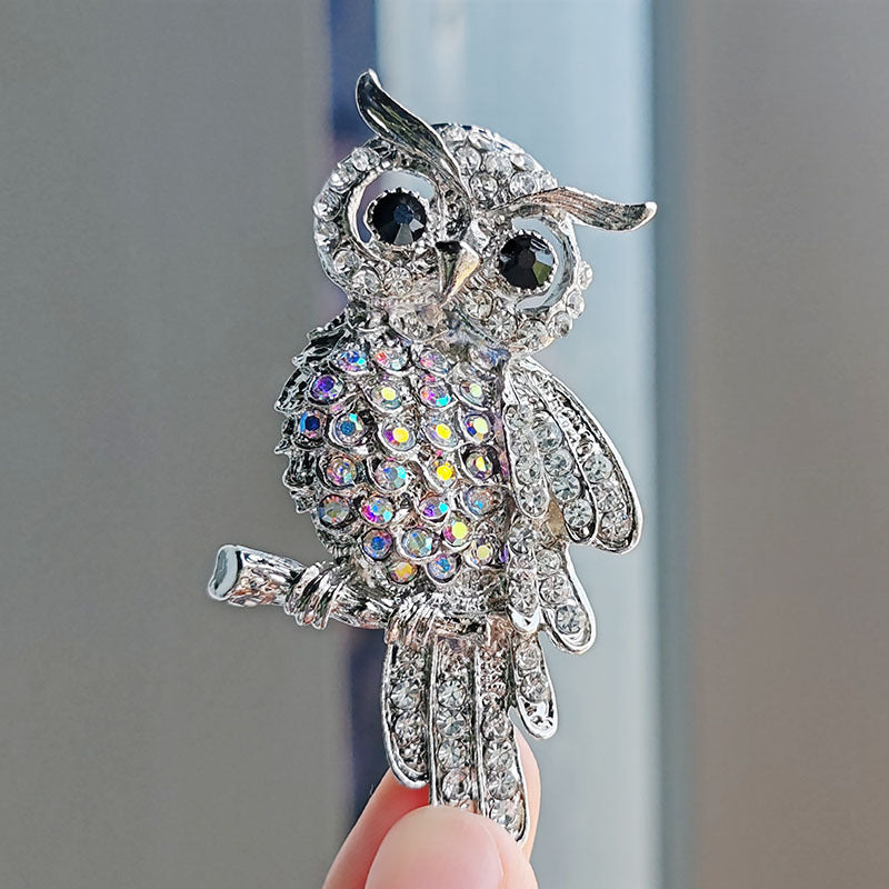 Close-up of the sparkling blue owl brooch showing detailed design