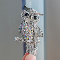 Close-up of the sparkling blue owl brooch showing detailed design