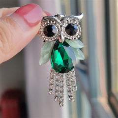 Alloy owl brooch with crystals against fabric