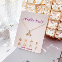 Close-up of gold crystal earrings with snowman design