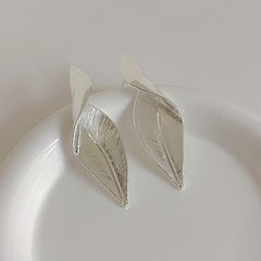 Close-up of gold and silver vintage leaf earrings