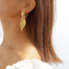 Silver leaf statement earrings worn by model