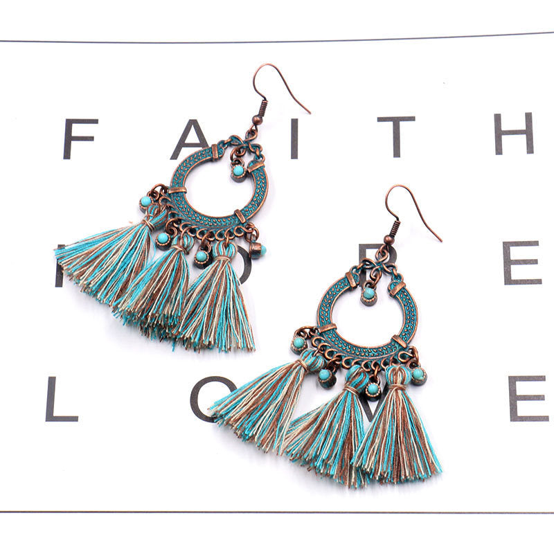 women wearing matching outfit with tassel earrings