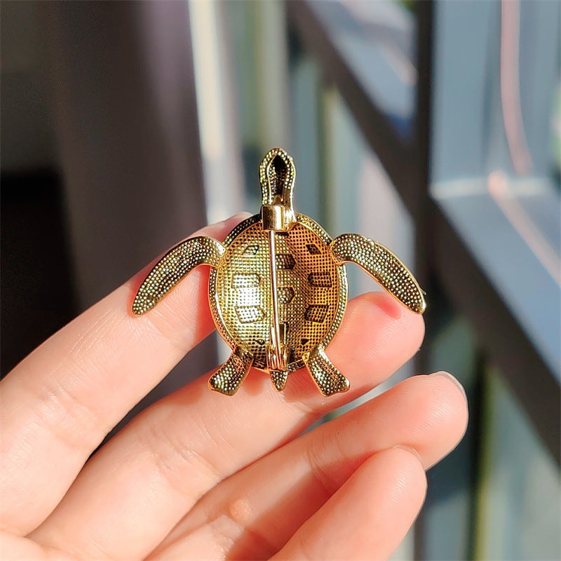 Gold animal pin photographed on a table